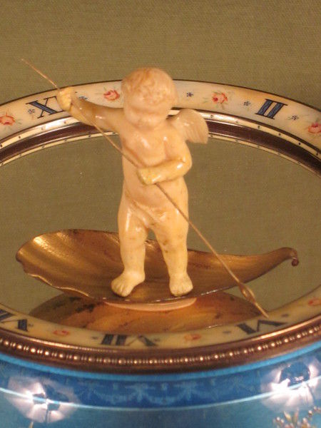 Silver and enamel novelty clock with rotating figure to show the time.    