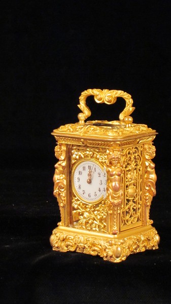 Miniature carriage clock with carytids, engraved panels and original case.  
