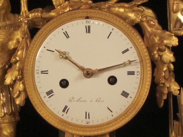 A fine fire-gilt mantel clock featuring a roman soldier and weapons.