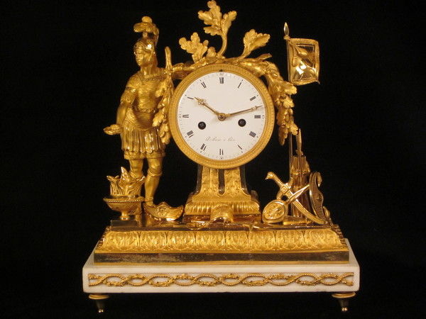A fine fire-gilt mantel clock featuring a roman soldier and weapons.