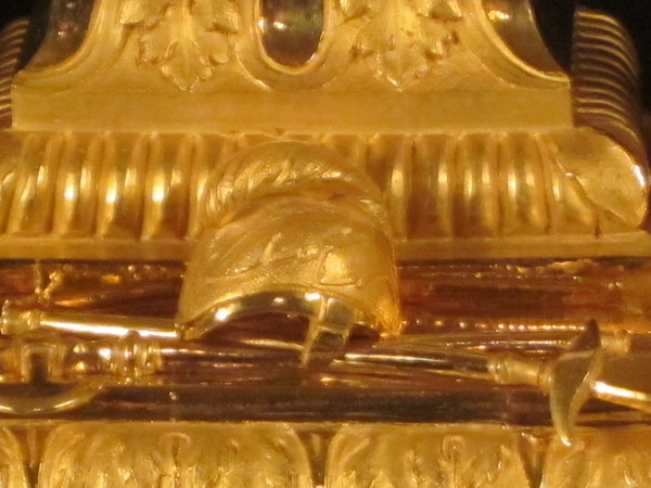 A fine fire-gilt mantel clock featuring a roman soldier and weapons.